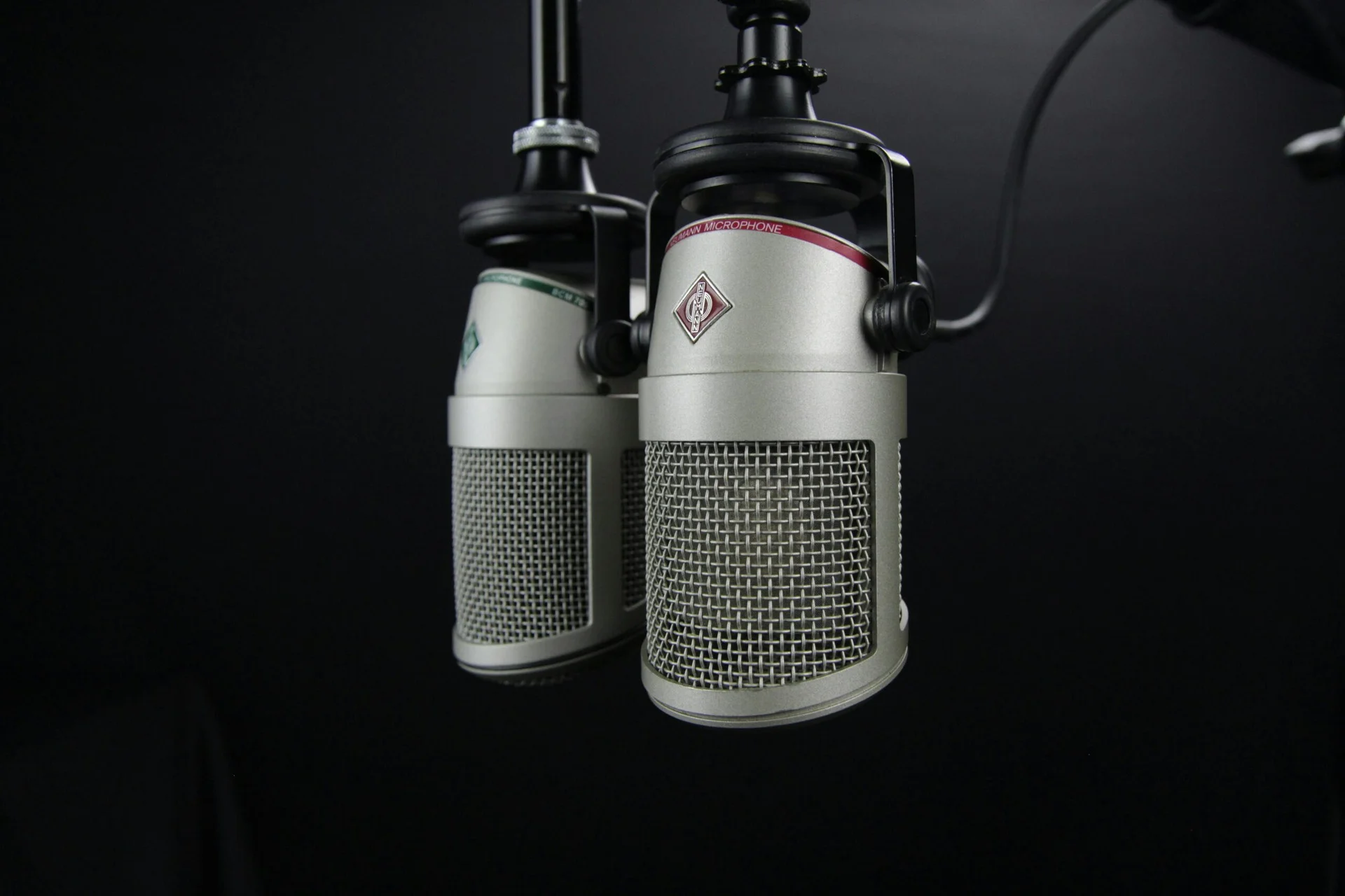 Zwei Studiomikrofone vor dunklem Hintergrund, Aufnahme für Podcast-Gespräche über Beziehung